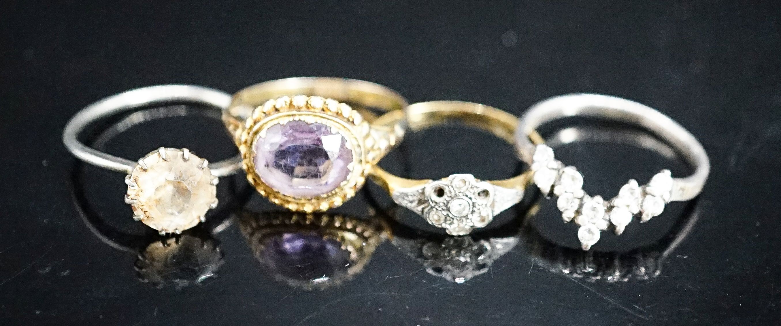 A Victorian yellow metal and amethyst dress ring (shank a.f.), gross 2.6 grams, size P/Q, a small diamond set ring(a.f.), gross 1.8 grams and two paste rings.